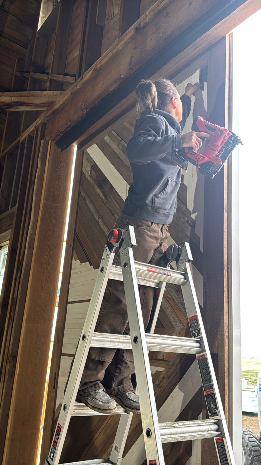 EM Designs artist installing reclaimed wood artwork